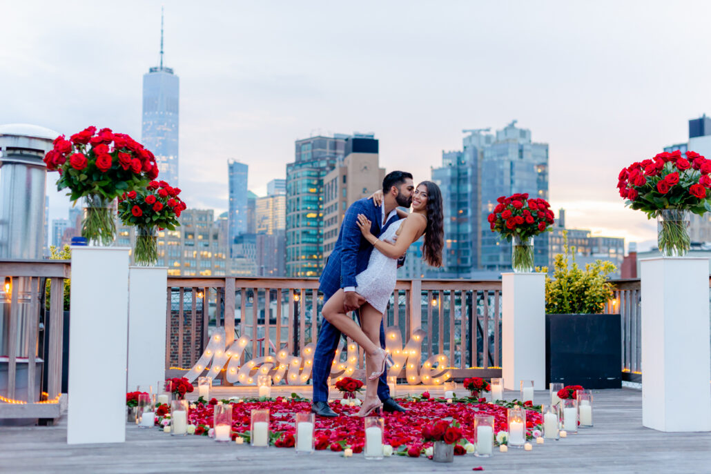 Gorgeous New York City engagement photography by Ash Fox on a rooftop with hundreds of red roses and petals